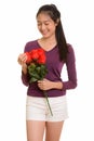 Young happy Asian teenage girl smiling holding red roses ready f Royalty Free Stock Photo