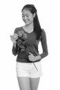 Young happy Asian teenage girl smiling holding red roses ready for Valentine`s day Royalty Free Stock Photo