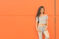 Young beautiful Asian teenage girl against orange wall Royalty Free Stock Photo