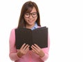 Young happy Asian teenage girl smiling and reading book Royalty Free Stock Photo