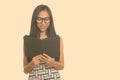 Young happy Asian teenage nerd girl smiling while reading book Royalty Free Stock Photo