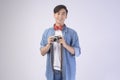 Young happy asian tourist man over white background studio, travel and holidays concept Royalty Free Stock Photo