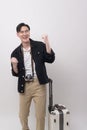 Young happy asian tourist man over white background studio, travel and holidays concept