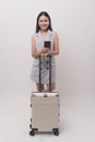 Young happy asian tourist woman over white background studio, travel and holidays concept Royalty Free Stock Photo