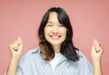 Young asian woman celebrates victory and success, feels lively and energetic over pink background