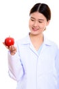 Young happy Asian woman doctor smiling while holding and looking Royalty Free Stock Photo