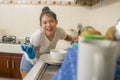Young happy Asian woman doing domestic chores - beautiful sweet and cute Chinese girl washing dishes in kitchen smiling relaxed Royalty Free Stock Photo