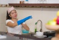 Young happy Asian woman doing domestic chores - beautiful sweet and cute Korean girl washing dishes in kitchen smiling relaxed Royalty Free Stock Photo