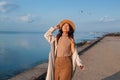 Happy asian woman with hands in the air walks on the seaside in autumn. Seagulls flying on the beach. Royalty Free Stock Photo