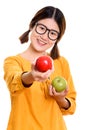 Young happy Asian woman smiling while holding green apple and gi Royalty Free Stock Photo