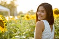 Young happy Asian woman smiling and looking back in the field of Royalty Free Stock Photo
