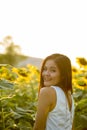 Young happy Asian woman smiling and looking back in the field of Royalty Free Stock Photo