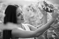 Young happy Asian woman smiling and looking at sunflower in the field of blooming sunflowers Royalty Free Stock Photo