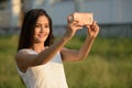 Young happy Asian woman smiling while taking selfie picture with Royalty Free Stock Photo