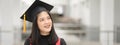 Young happy Asian woman university graduate in graduation gown and cap in the college campus. Education stock photo Royalty Free Stock Photo