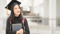 Young happy Asian woman university graduate in graduation gown and cap in the college campus. Education stock photo Royalty Free Stock Photo