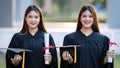 Young happy Asian woman university graduates in graduation gown and mortarboard hold a degree certificate celebrate education Royalty Free Stock Photo