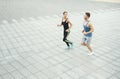 Young woman and man running in city copy space Royalty Free Stock Photo