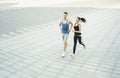 Young woman and man running in city copy space Royalty Free Stock Photo