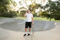 Young happy and attractive American man 30s standing holding skate board after sport boarding training session talking on mobile p