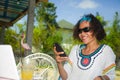 Young happy and attractive Asian American mixed ethnicity woman working with laptop computer and mobile phone from beautiful cafe Royalty Free Stock Photo