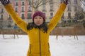 Young happy and attractive Asian Korean woman in Winter jacket and beanie enjoying snowfall at city park playing cheerful Royalty Free Stock Photo