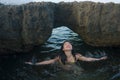 Young happy and attractive Asian woman in the sea - cheerful and carefree Chinese girl playful in the water during Summer holidays