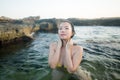 Young happy and attractive Asian woman in the sea - cheerful and carefree Chinese girl playful in the water during Summer holidays