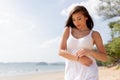 Young happy attractive and beautiful Caucasian adult woman in white summer dress enjoying summer time on tropical beach - waist up Royalty Free Stock Photo