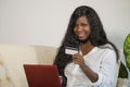 Young happy and attractive black African American woman using credit card and laptop computer banking online and shopping on inter Royalty Free Stock Photo