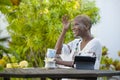 Young happy and attractive black afro American woman working with tablet outdoors at cafe relaxed drinking tea or coffee in digita Royalty Free Stock Photo