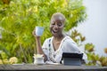 Young happy and attractive black afro American woman working with tablet outdoors at cafe relaxed drinking tea or coffee in digita Royalty Free Stock Photo