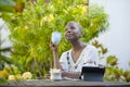 Young happy and attractive black afro American woman working with tablet outdoors at cafe relaxed drinking tea or coffee in digita Royalty Free Stock Photo