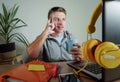 Young happy and attractive business man at home office drinking coffee cup looking satisfied and confident working with laptop com Royalty Free Stock Photo