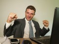 Young happy and attractive business man working at office computer desk celebrating success gesturing excited and cheerful in Royalty Free Stock Photo