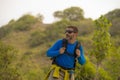 Young happy and attractive hiker man with backpack walking around in the wood enjoying hiking activity and nature in sport and lif