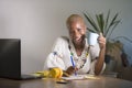 Young happy and attractive hipster black afro American woman drinking tea or coffee at home office working cheerful with laptop co Royalty Free Stock Photo
