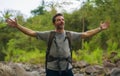 Young happy and attractive man with travel backpack hiking in river at forest feeling free enjoying nature and fresh environment Royalty Free Stock Photo