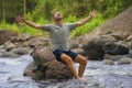 Young happy and attractive man with travel backpack hiking in river at forest feeling free enjoying nature and fresh environment Royalty Free Stock Photo