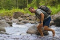 Young happy and attractive man with travel backpack hiking in river at forest feeling free enjoying nature and fresh environment Royalty Free Stock Photo
