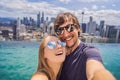 Young happy and attractive playful couple taking selfie picture together at luxury urban hotel infinity pool and