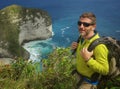 Young happy and attractive sporty hiker man with trekking backpack hiking at sea cliff landscape feeling free enjoying travel