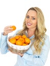 Young Happy Attractive Woman Holding a Basket of Tangerines Royalty Free Stock Photo