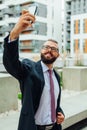 Young happy bearded businessman standing outside office building Royalty Free Stock Photo