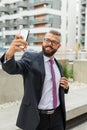 Young happy bearded businessman standing outside office building Royalty Free Stock Photo