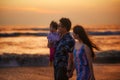 Young happy and beautiful Asian Chinese couple holding baby girl daughter walking on sunset beach enjoying together romantic Royalty Free Stock Photo