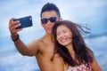 Young happy and beautiful Asian Chinese couple taking selfie photo with mobile phone camera smiling joyful Royalty Free Stock Photo