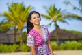 Young happy beautiful Asian Chinese tourist woman smiling relaxed wearing sweet dress walking at beach tropical resort on holidays Royalty Free Stock Photo