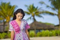 Young happy beautiful Asian Chinese tourist woman smiling relaxed wearing sweet dress walking at beach tropical resort on holidays Royalty Free Stock Photo