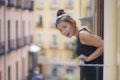 Young happy and beautiful Asian Chinese woman in hair bun enjoying city view from hotel room balcony in Spain during holidays trip Royalty Free Stock Photo